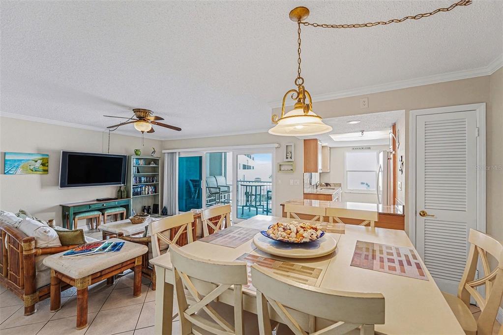 A dining room features a light-colored wooden table, six chairs, and a hanging pendant light — 19500 GULF BOULEVARD UNIT 102, INDIAN SHORES, FL