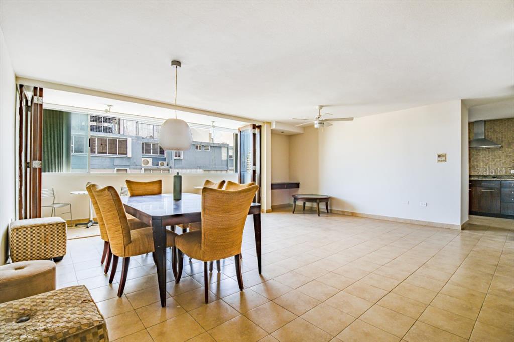 A dining area with a table and chairs sits in a large room with tile floors — FULL POWER GENERATOR KINGS COURT 80 STREET UNIT 804, SAN JUAN, PR
