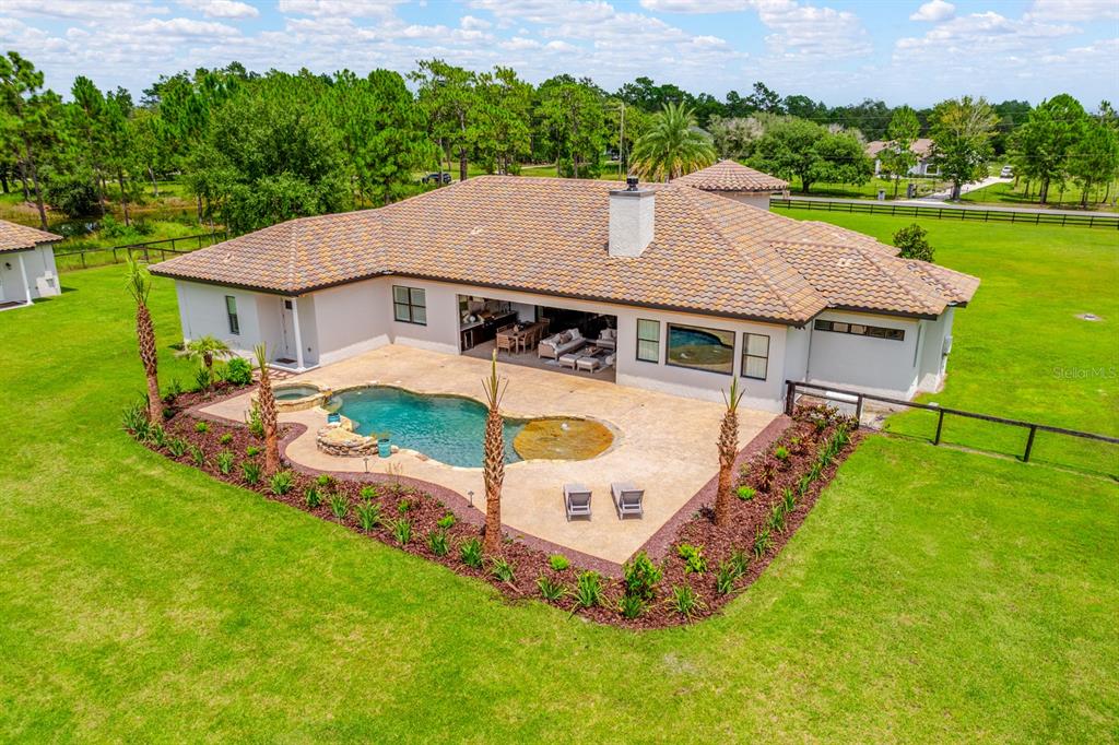 An aerial view of a house with a tiled roof, pool, and patio in a yard — 4156 BENEDICT AVENUE, ORLANDO, FL