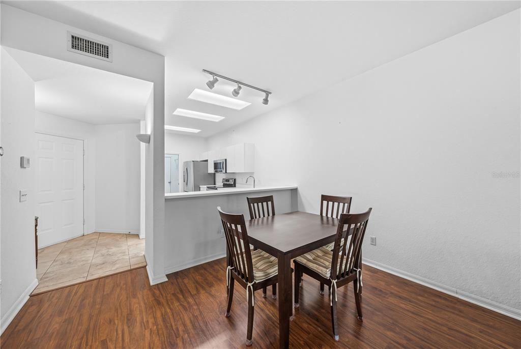 A dining area with a wooden table and chairs sits adjacent to an open kitchen — 22128 LITTLE LAGOON COURT, LUTZ, FL