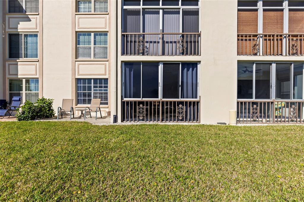 The exterior of a multi-story apartment building features ground-level patios and upper-level balconies — 19029 US HIGHWAY 19 N UNIT 7-9, CLEARWATER, FL