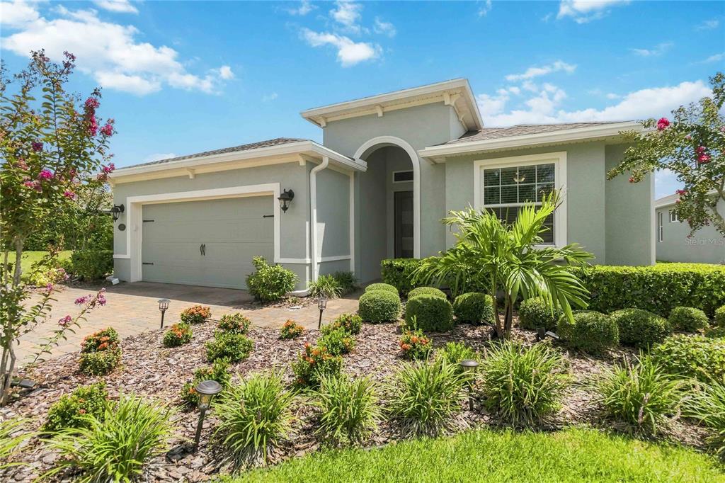 A single-story house with a light green exterior, a two-car garage, and landscaped front yard — 1212 VICTORIA HILLS DRIVE N, DELAND, FL