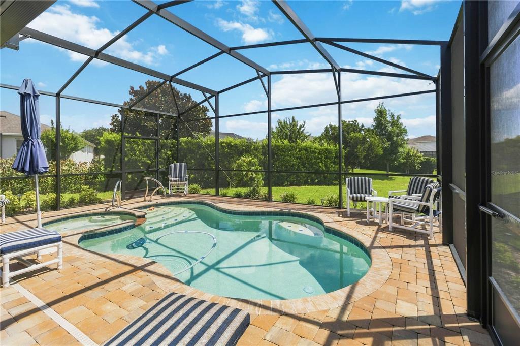 A screened-in patio features a swimming pool, a hot tub, and outdoor seating — 1212 VICTORIA HILLS DRIVE N, DELAND, FL