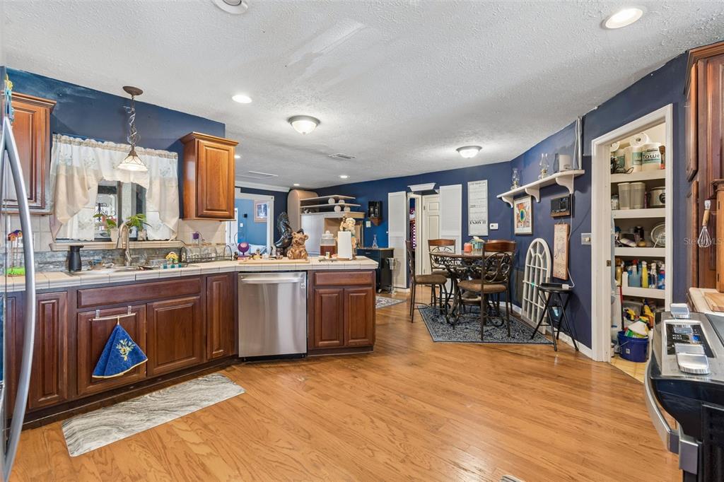 A view from an entryway into a dining room with hardwood floors and blue walls — 5059 BERNADETTE DRIVE, ZEPHYRHILLS, FL