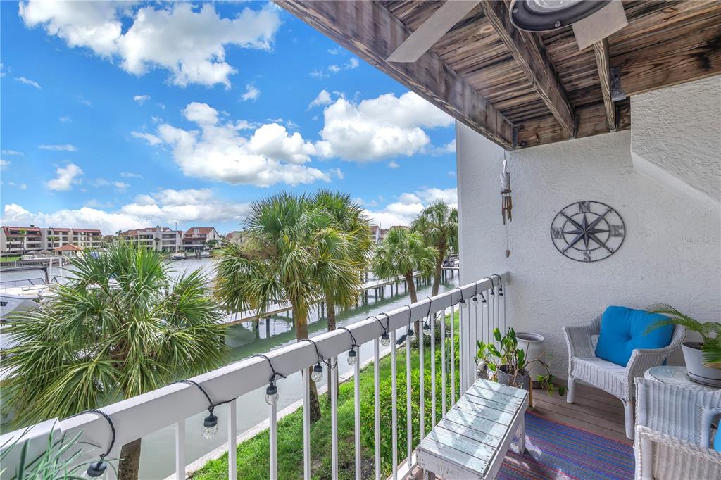 A row of multi-story townhomes with covered ground-level parking and palm trees in front — 117 YACHT CLUB LANE, TIERRA VERDE, FL