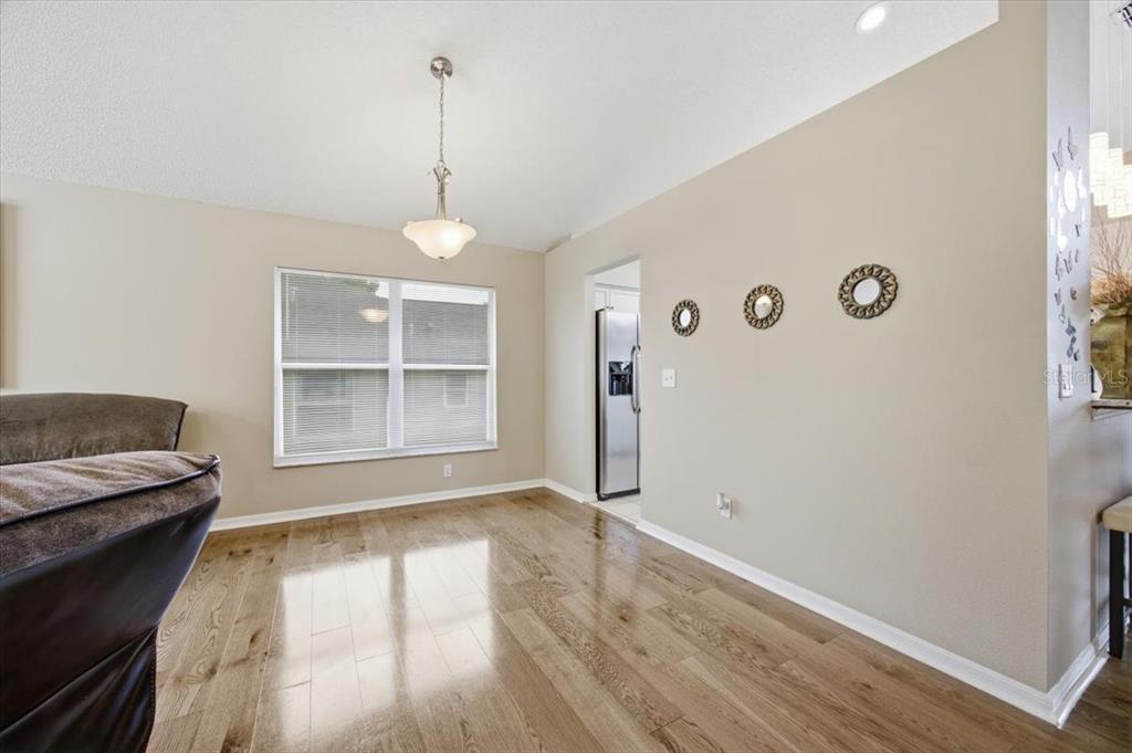 A living room features hardwood floors, a large sectional sofa, and a vaulted ceiling — 227 DILLON WAY, DAVENPORT, FL