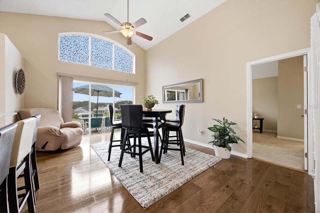 A living room features hardwood floors, a large sectional sofa, and a window with blinds — 227 DILLON WAY, DAVENPORT, FL