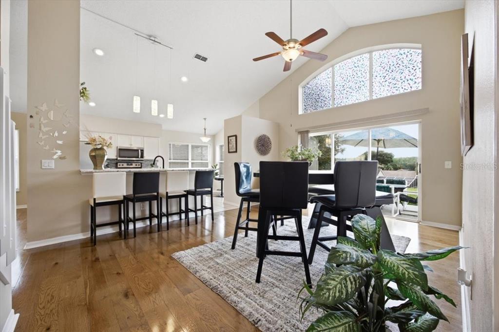 An interior view of a foyer with a staircase, hardwood floors, and a front door — 227 DILLON WAY, DAVENPORT, FL