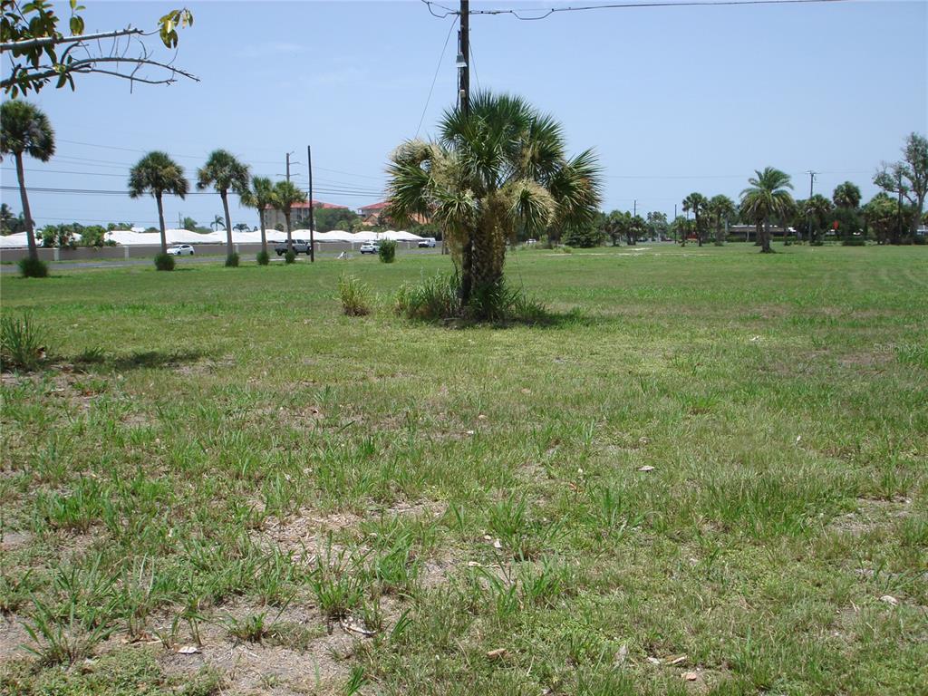 A large, grassy vacant lot sits in front of several suburban houses and trees — 2301 S TAMIAMI TRAIL, OSPREY, FL