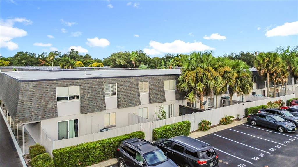 An exterior view of a two-story apartment building with a parking lot and palm trees — 1928 CONWAY RD UNIT 33, ORLANDO, FL