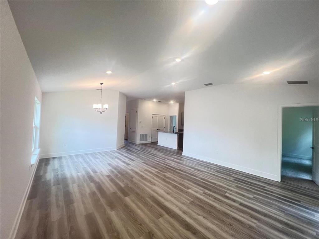 An open-concept living area features light wood-look flooring, recessed lighting, and a kitchen island — 3648 LINDBERGH STREET, LAKELAND, FL