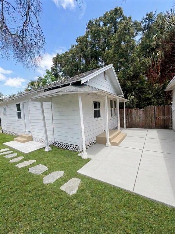 A white wood-sided house features a covered porch and a new concrete patio — 1543 43RD STREET S UNIT B, ST PETERSBURG, FL