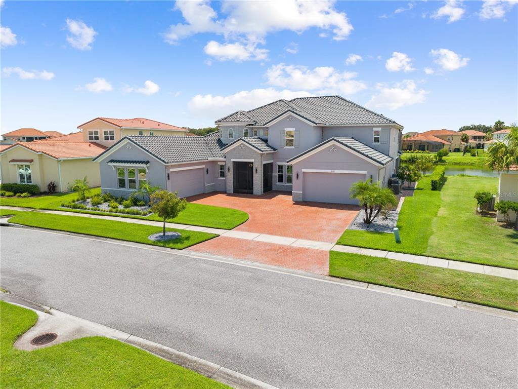 A two-story gray house with a tiled roof and a red brick driveway — 840 SPINNAKER WAY, KISSIMMEE, FL