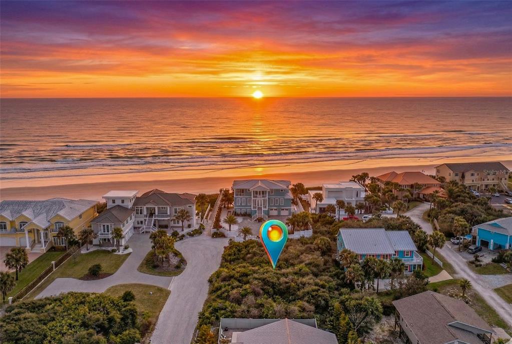 An aerial view shows a vacant, brush-covered lot situated between beach houses at sunset — 21 JESSICA LYNN PLACE, ST AUGUSTINE, FL