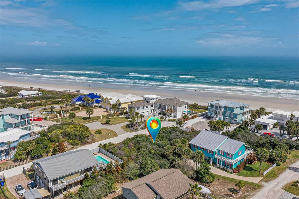 An aerial view shows a vacant, wooded lot situated between beach houses near the ocean — 21 JESSICA LYNN PLACE, ST AUGUSTINE, FL