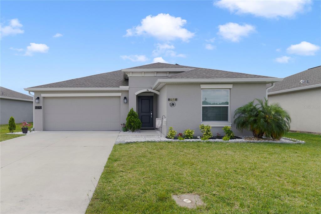 A single-story gray house with a two-car garage and a front lawn — 5270 PRESERVE BOULEVARD, ST CLOUD, FL