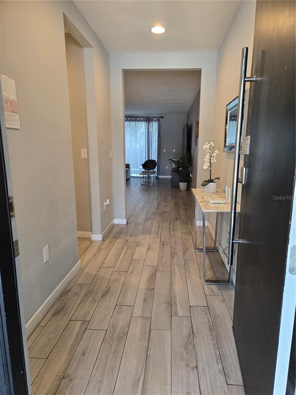 A covered outdoor patio features stone tile flooring, modern metal furniture, and sliding glass doors — 4453 LE REVE COURT, KISSIMMEE, FL