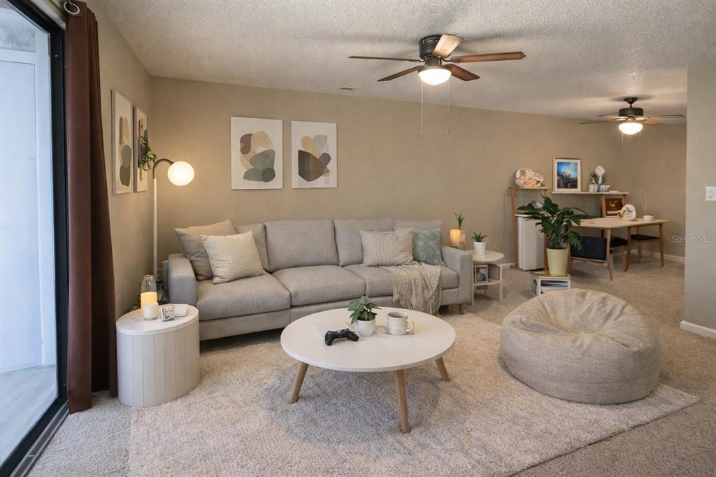 A living room features a light gray sofa, a round coffee table, and a beanbag chair — 2834 SW 14TH DRIVE UNIT 305, GAINESVILLE, FL