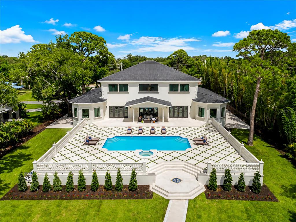 An aerial view of a two-story house with a large pool and patterned stone patio — 1516 BAYSHORE BOULEVARD, DUNEDIN, FL