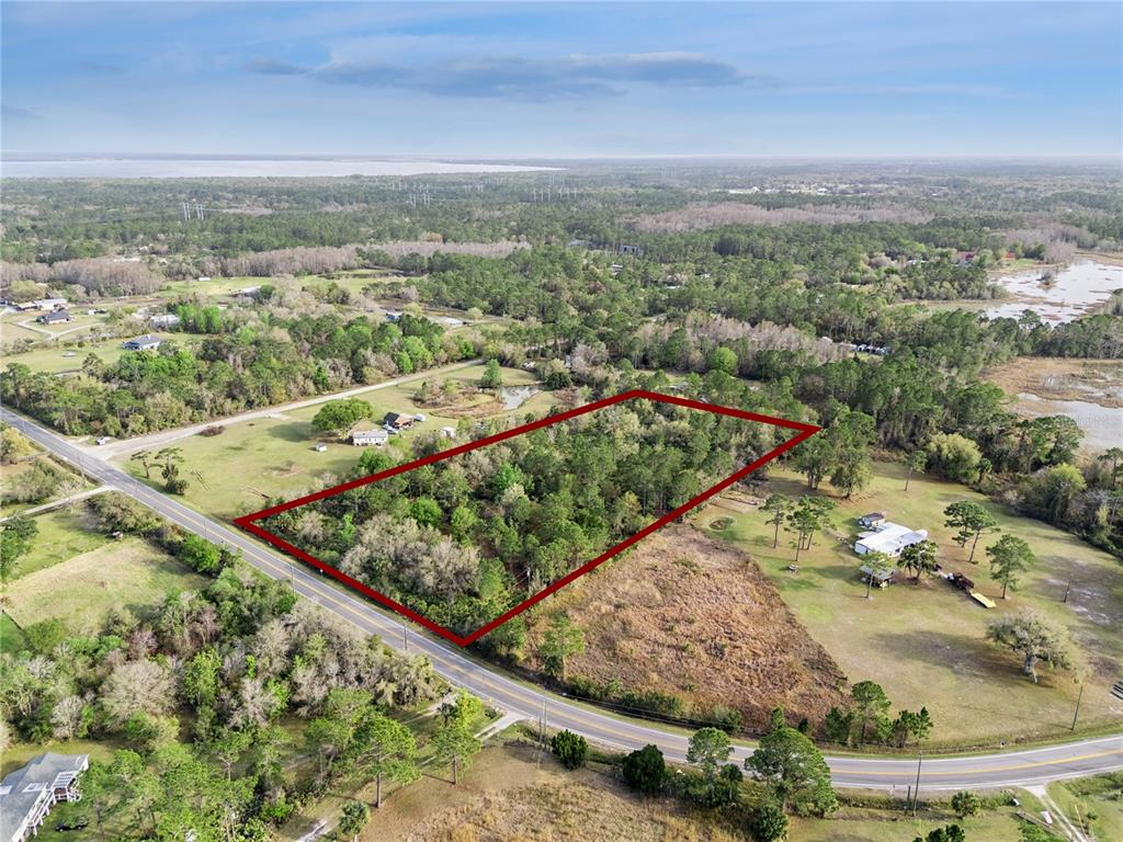 An aerial view shows a rectangular plot of land outlined in red along a road — 541 E OSCEOLA ROAD, GENEVA, FL