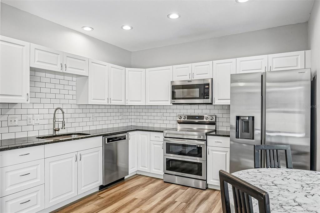 A two-story house with a gray exterior, a purple front door, and a large front tree — 24348 SUMMER WIND COURT, LUTZ, FL
