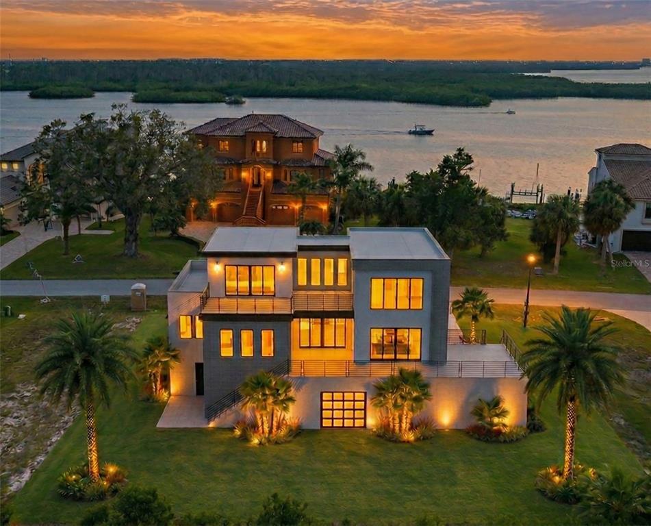 An aerial view of a modern multi-story house with a flat roof at sunset — 25 HARBORPOINTE DRIVE, PORT RICHEY, FL