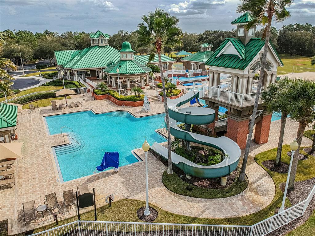 An aerial view shows yellow multi-story townhomes surrounded by dense trees under a cloudy sky — 8116 STONE PATH WAY, TAMPA, FL