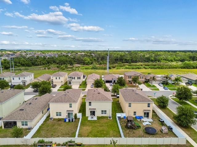 An aerial view shows several suburban houses with fenced backyards and a surrounding green landscape — 11181 LELAND GROVES DRIVE, RIVERVIEW, FL