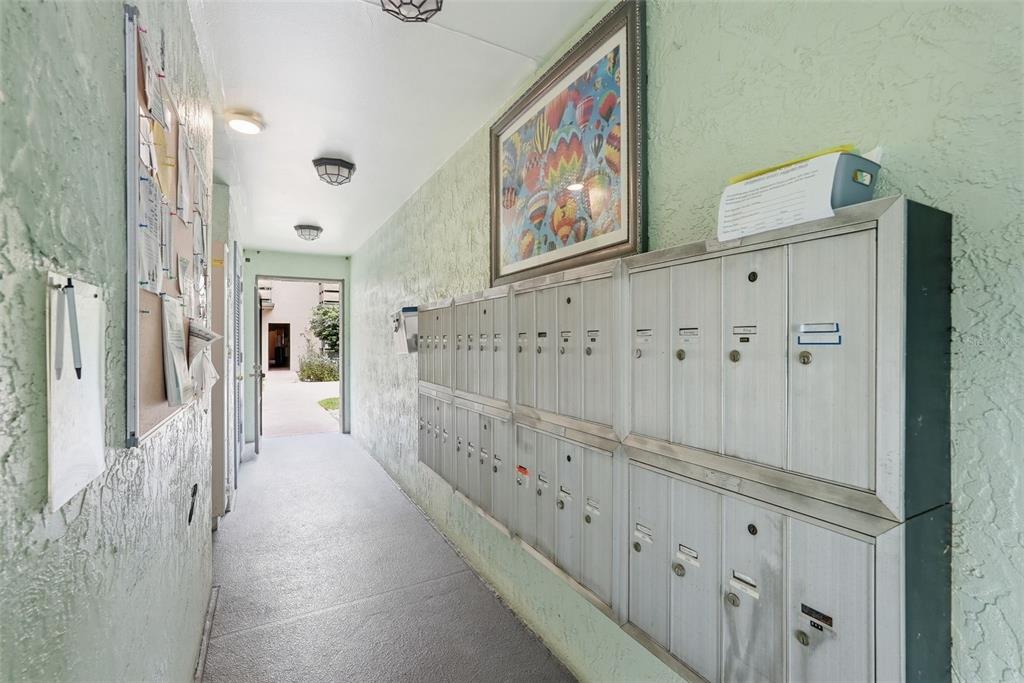 A hallway features a wall of metal mailboxes, a bulletin board, and a framed picture — 5973 TERRACE PARK DRIVE N UNIT 109, ST PETERSBURG, FL