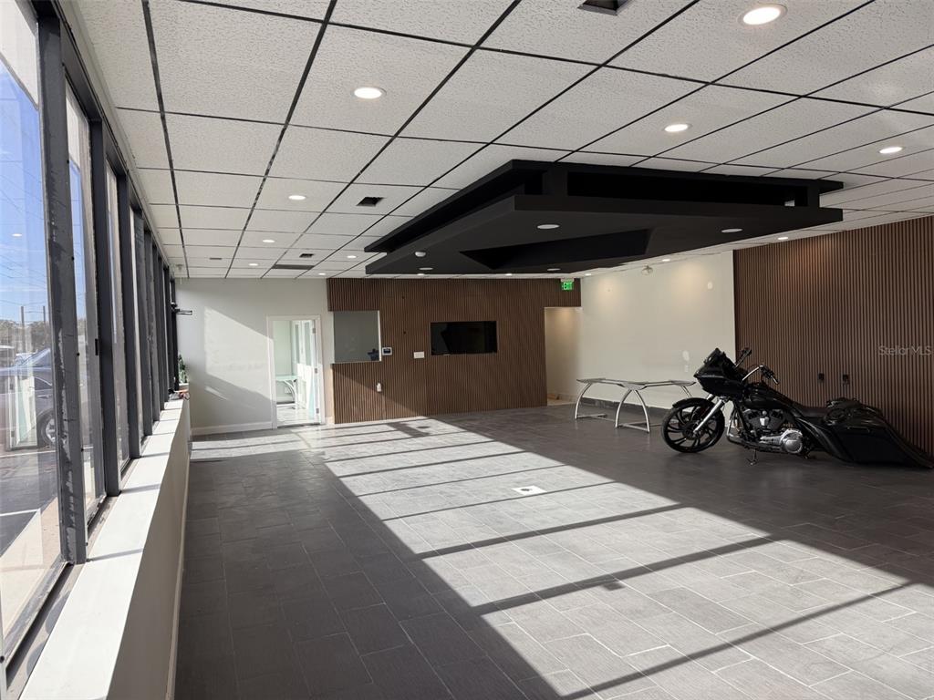 A commercial space features gray tile flooring, a black drop ceiling accent, and a parked motorcycle — 5005 EDGEWATER DRIVE, ORLANDO, FL
