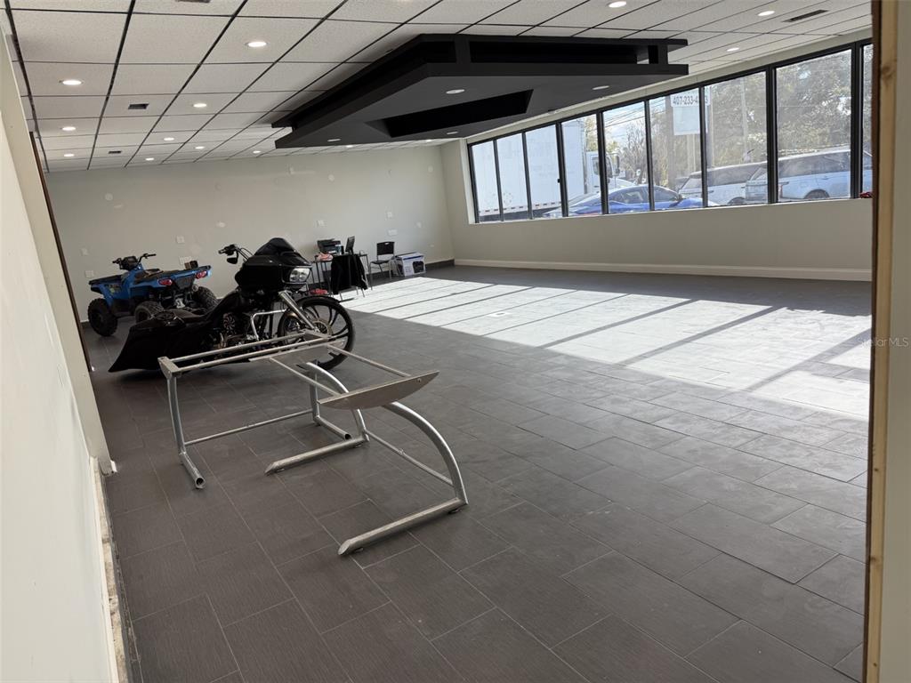 A commercial space with gray tile flooring, a black ceiling feature, and large windows — 5005 EDGEWATER DRIVE, ORLANDO, FL