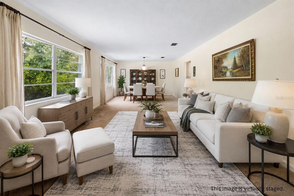 A spacious living and dining area with beige carpeting, neutral walls, and traditional furniture — 6267 CLANCE ROAD, KEYSTONE HEIGHTS, FL