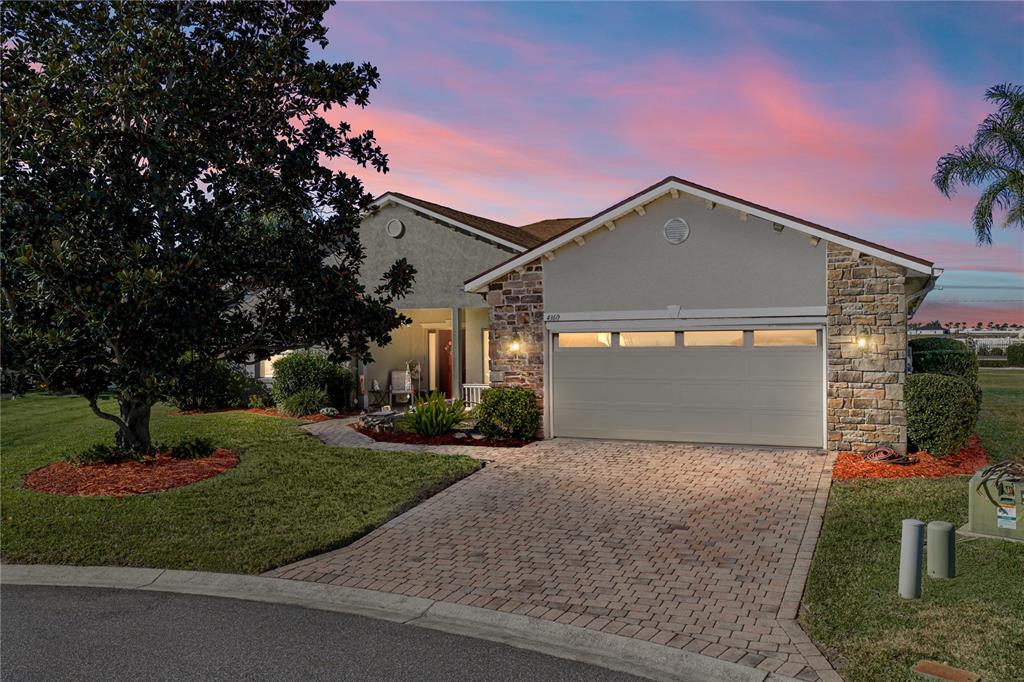 A single-story house with a stone-accented facade, a two-car garage, and a paved driveway — 4360 ASHTON CLUB DRIVE, LAKE WALES, FL
