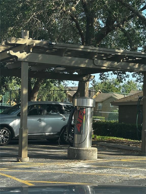 An outdoor air pump station sits under a wooden pergola in a parking lot — 420 SUMMIT RIDGE PLACE UNIT 204, LONGWOOD, FL