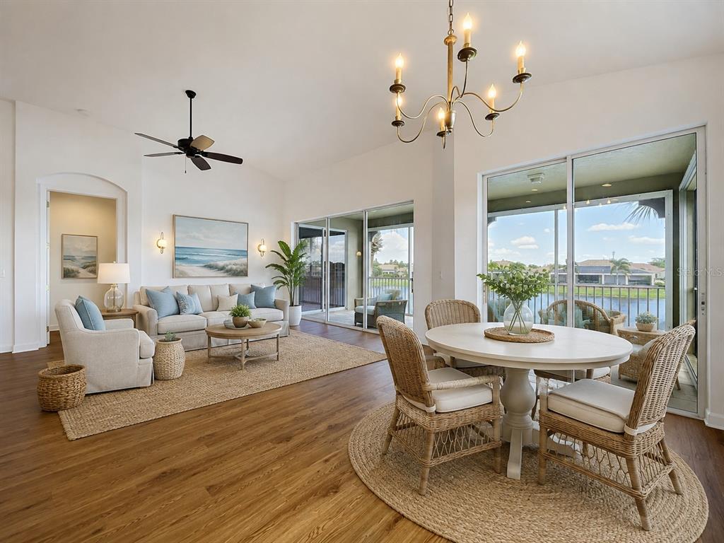 A living and dining area with wood floors, wicker furniture, and large sliding glass doors — 1338 EMERALD DUNES DRIVE UNIT 35, SUN CITY CENTER, FL
