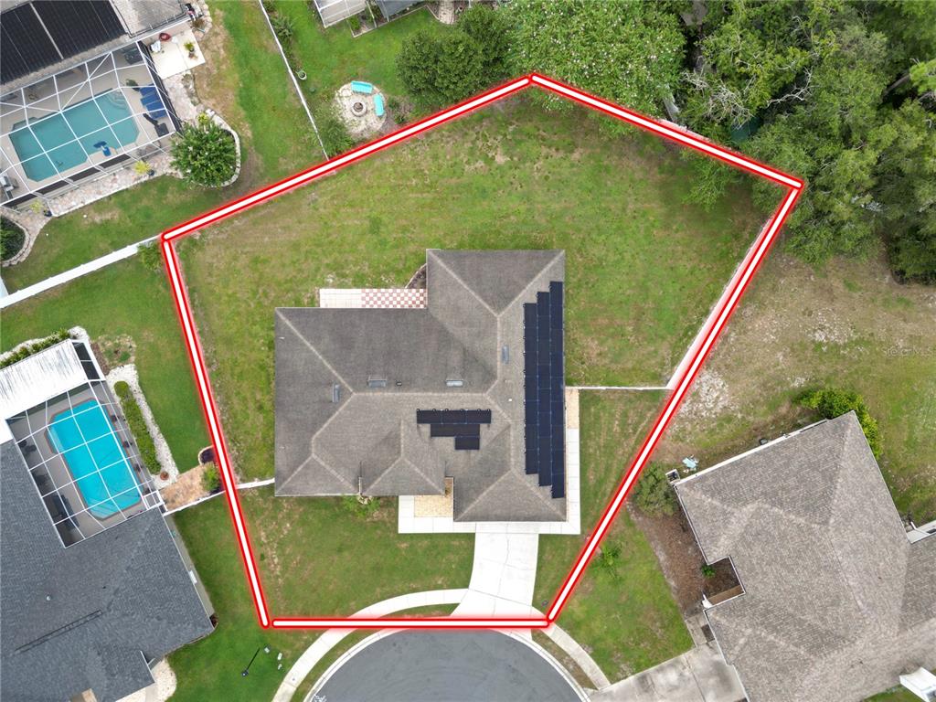 An aerial view shows a house with solar panels on a large, irregularly shaped lot — 1564 NORWICK WAY, LAKELAND, FL
