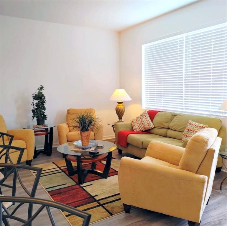 A living room features yellow armchairs, a sofa, a glass coffee table, and a patterned rug — 801 BENOI DRIVE, DAVENPORT, FL