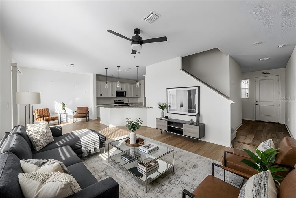 A living room with a sectional sofa, coffee table, and open kitchen in the background — 2854 89TH STREET CIRCLE E, PALMETTO, FL