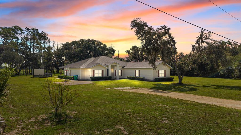 A single-story house with light siding and a metal roof sits on a grassy lot — 324 NE 300TH STREET, CROSS CITY, FL