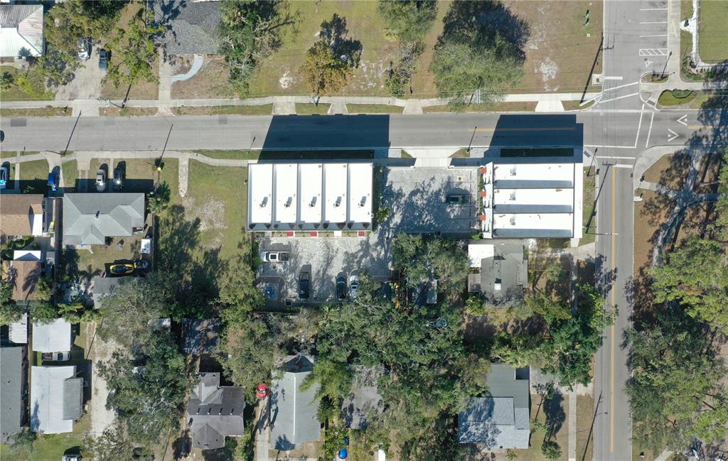 An aerial view shows a commercial building with a parking lot next to residential houses — 1744 10TH STREET, SARASOTA, FL