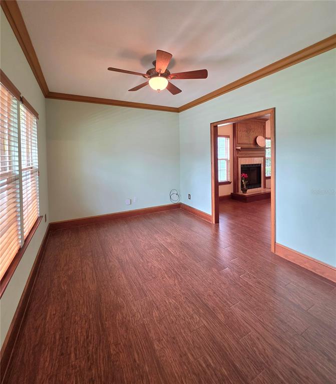 An empty room with light green walls, wood flooring, and a ceiling fan — 4326 SW 80TH STREET, GAINESVILLE, FL