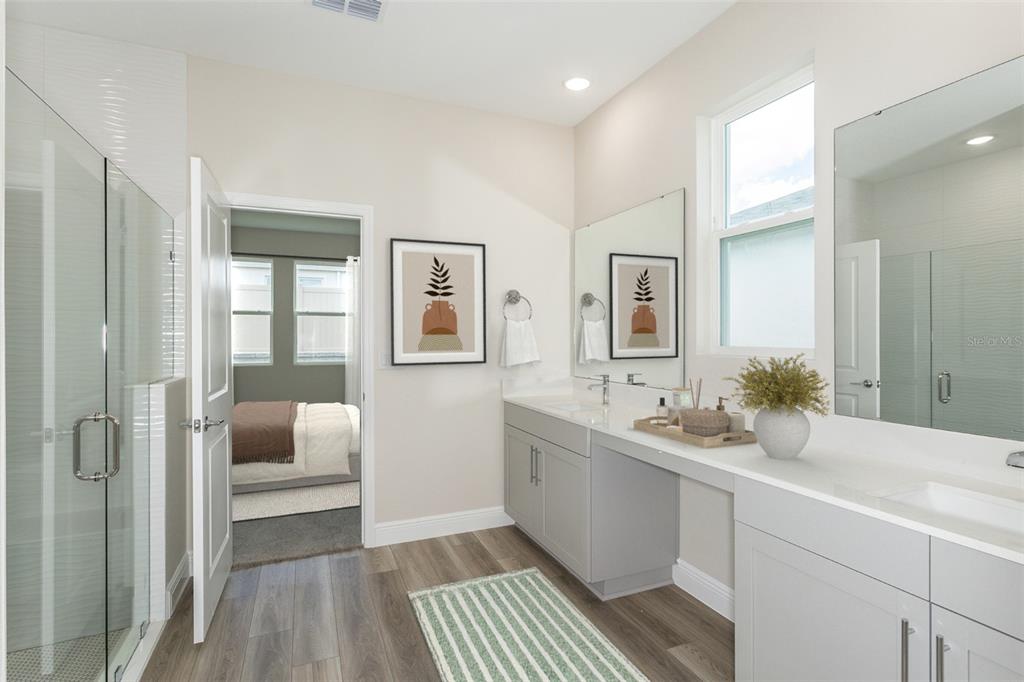 A bathroom features a glass-enclosed shower, dual vanity with gray cabinets, and a striped rug — 33531 HAMMOCK BEACH WAY, DADE CITY, FL