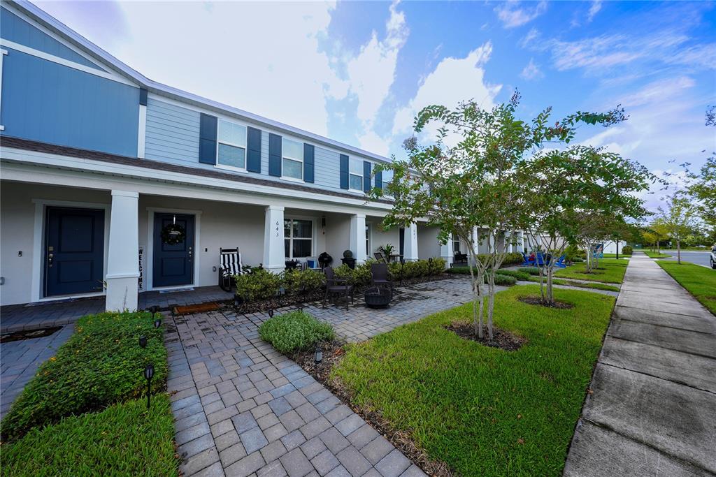 A row of townhomes features blue siding, white columns, and paved front patios — 643 BELGROVE STREET, DEBARY, FL