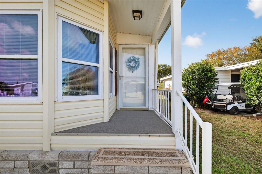 A yellow mobile home with a small front porch, white railings, and a golf cart — 3117 MANATEE ROAD, TAVARES, FL