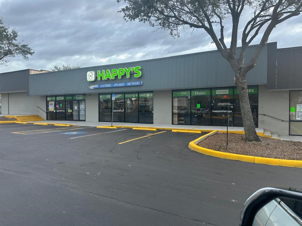 The exterior of a retail store named Happy's with a parking lot in front — 1727 E BUSCH BOULEVARD, TAMPA, FL