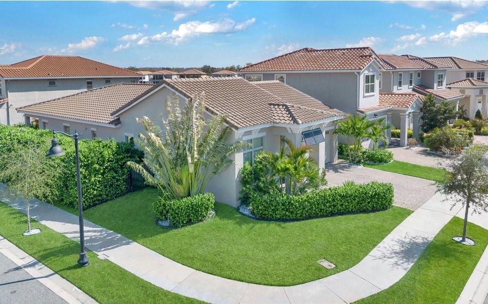 A corner lot view of a tan suburban house with a tile roof and landscaping — 13321 OAKENSHAW LANE, ORLANDO, FL