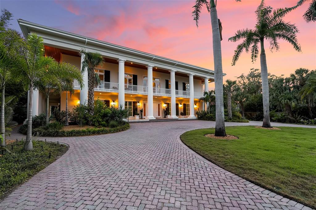An aerial view shows a beachfront property with a large house and adjacent wooded lot — 8132 SANDERLING ROAD, SARASOTA, FL
