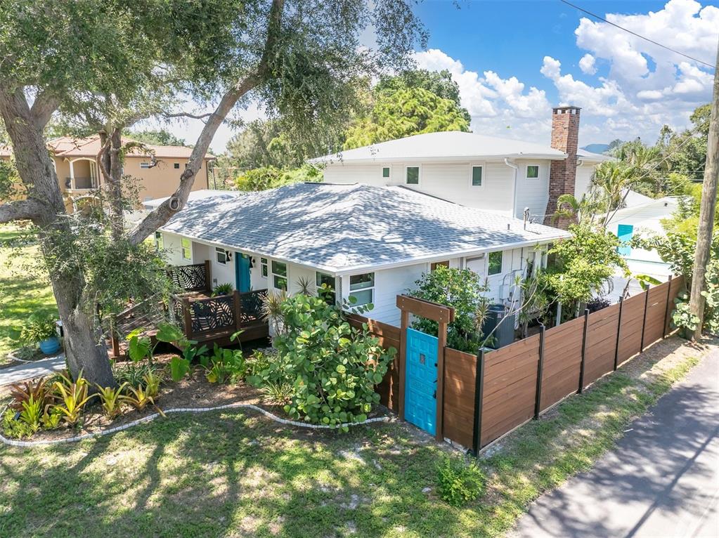 A two-story house with a wooden fence, a teal gate, and a front deck — 6921 MANGO AVENUE S, ST PETERSBURG, FL