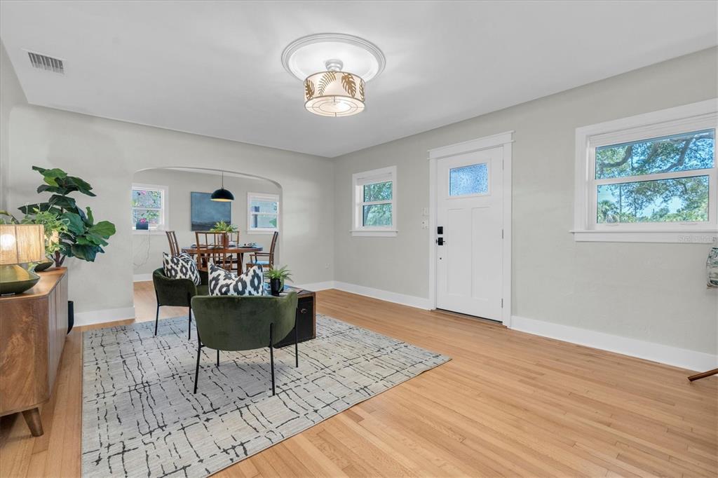 A front porch with wooden steps, decorative metal railings, and a teal front door — 6921 MANGO AVENUE S, ST PETERSBURG, FL