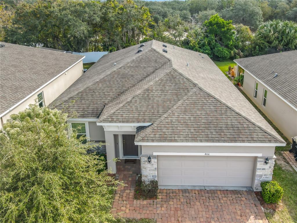 An aerial view shows the front exterior of a single-story house with a shingled roof — 806 BENJAMIN TRAIL, DAVENPORT, FL